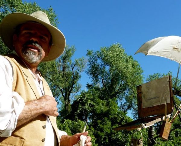 This is a photo of Stefan Baumann looking directly into the camera with his painting hat on and a friendly smile on his face.