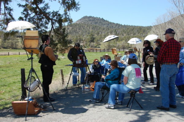 This is a photo of painters at a Summer Workshop who are listening to information and painting tips from Stefan Baumann before beginning to paint.